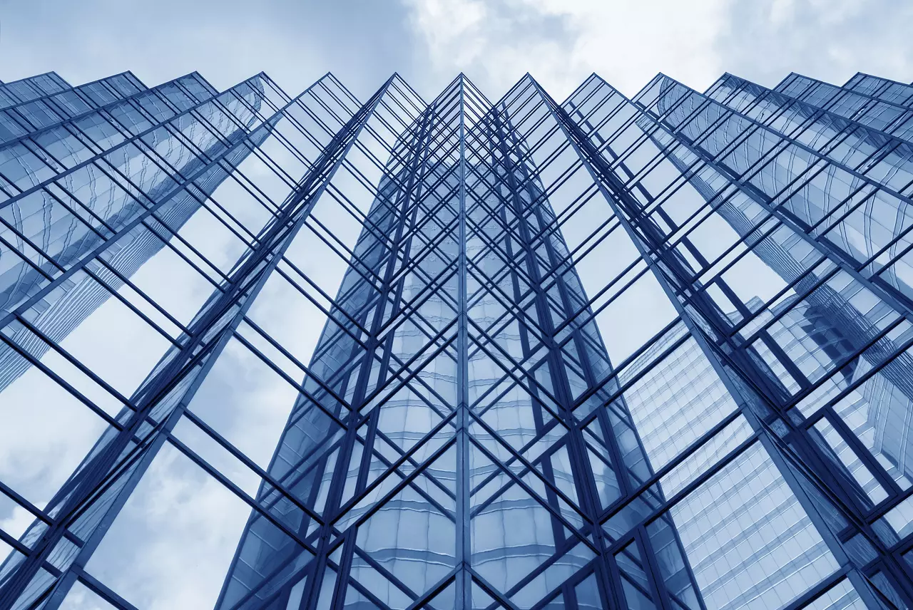 Looking up at the glass façade of a modern office building