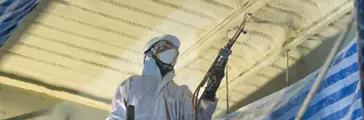 Technician spraying foam insulation