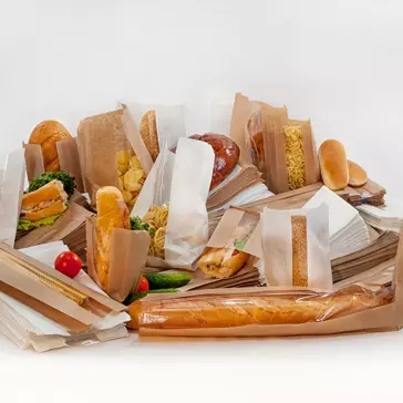 Different breads and sandwiches in paper packaging against a white background 