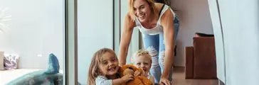 Mother pushing children sitting in laundry basket