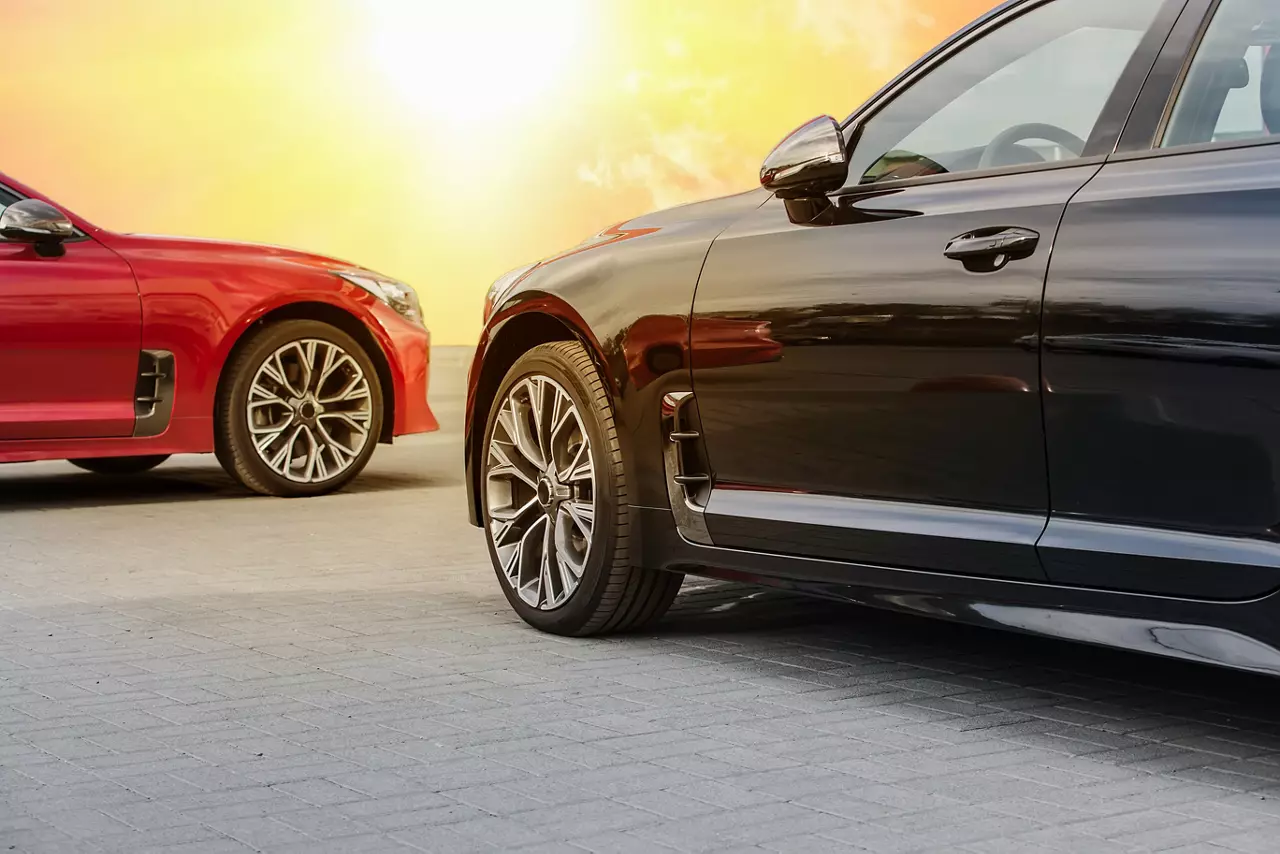 Red and black cars under a bright sunny sky in the afternoon