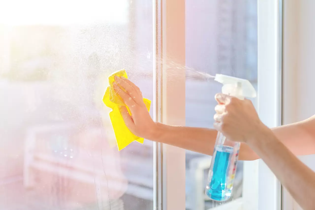 Washing the glass on the windows with cleaning spray