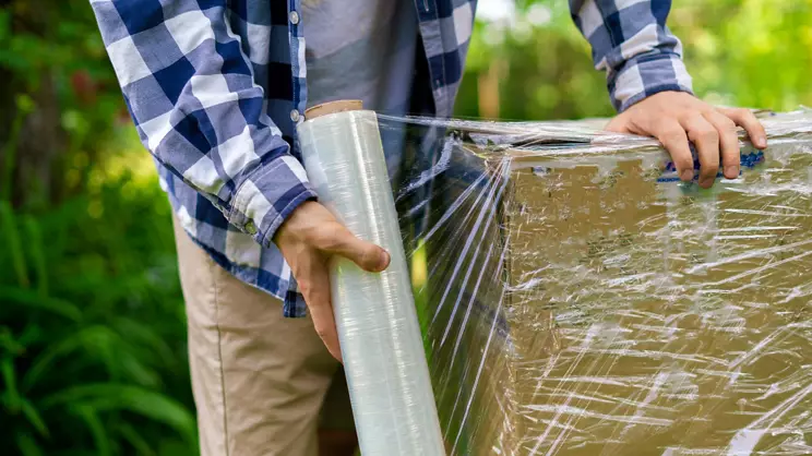 stretch wrap roll, man packing the box for shipping