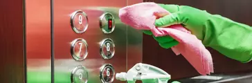 Person cleaning elevator buttons 