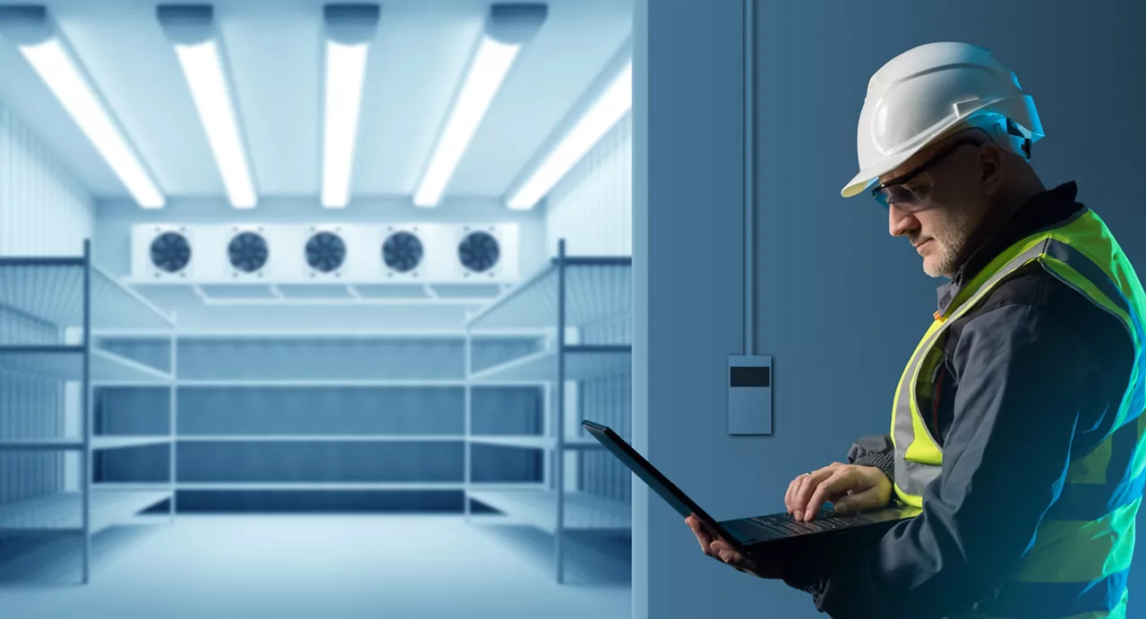 Male engineer on a computer setting up energy-efficient refrigeration equipment 