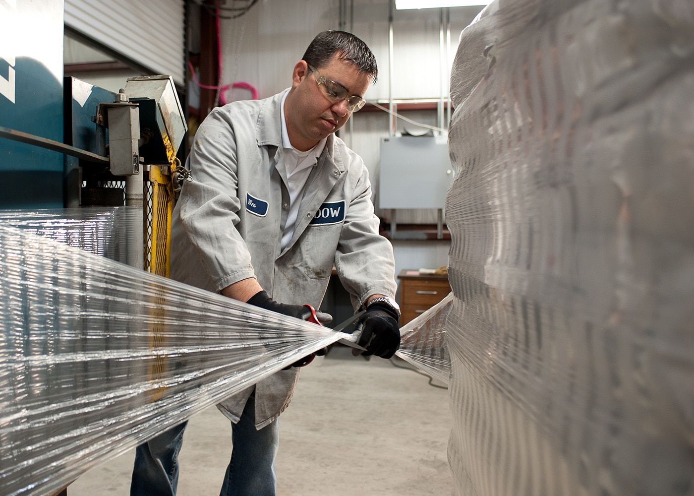Warehouse employee applying shrink wrap to a pallet