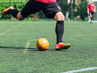 soccer player kicking a ball on the field