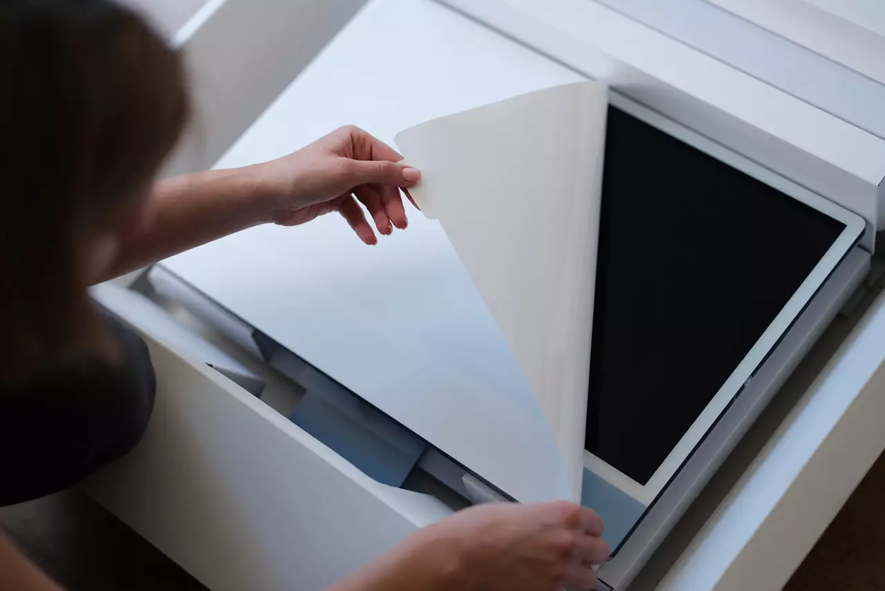 Person removes protective film from new monitor screen